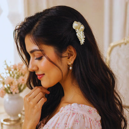 Woman with a decorative hair clip and floral dress in a softly lit room.