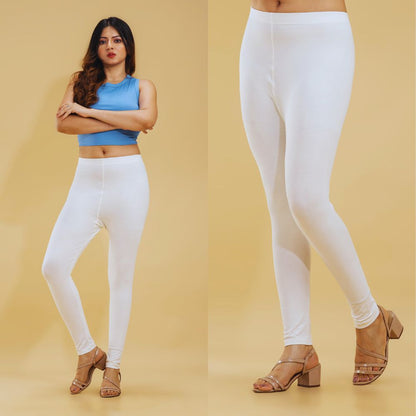 Woman wearing white leggings with a plain background