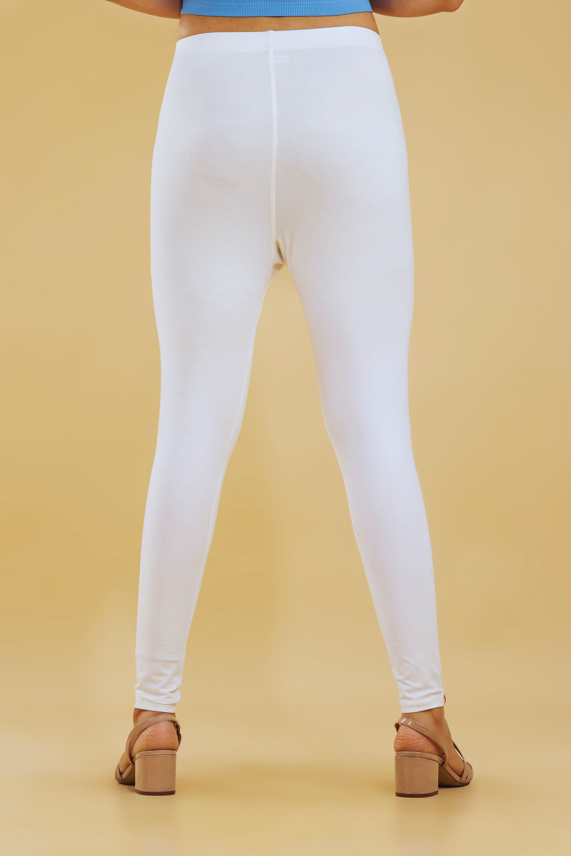 White leggings worn by a person on a beige background