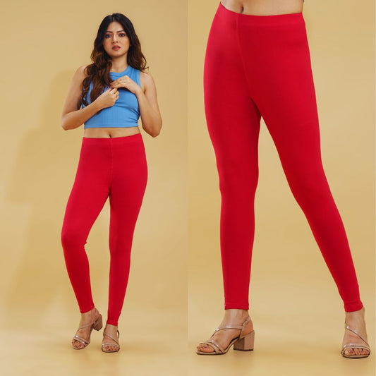 Woman wearing red leggings with a plain background