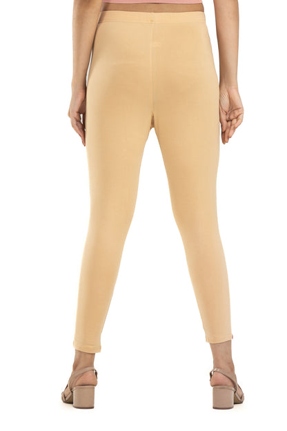 Beige leggings worn by a person on a white background