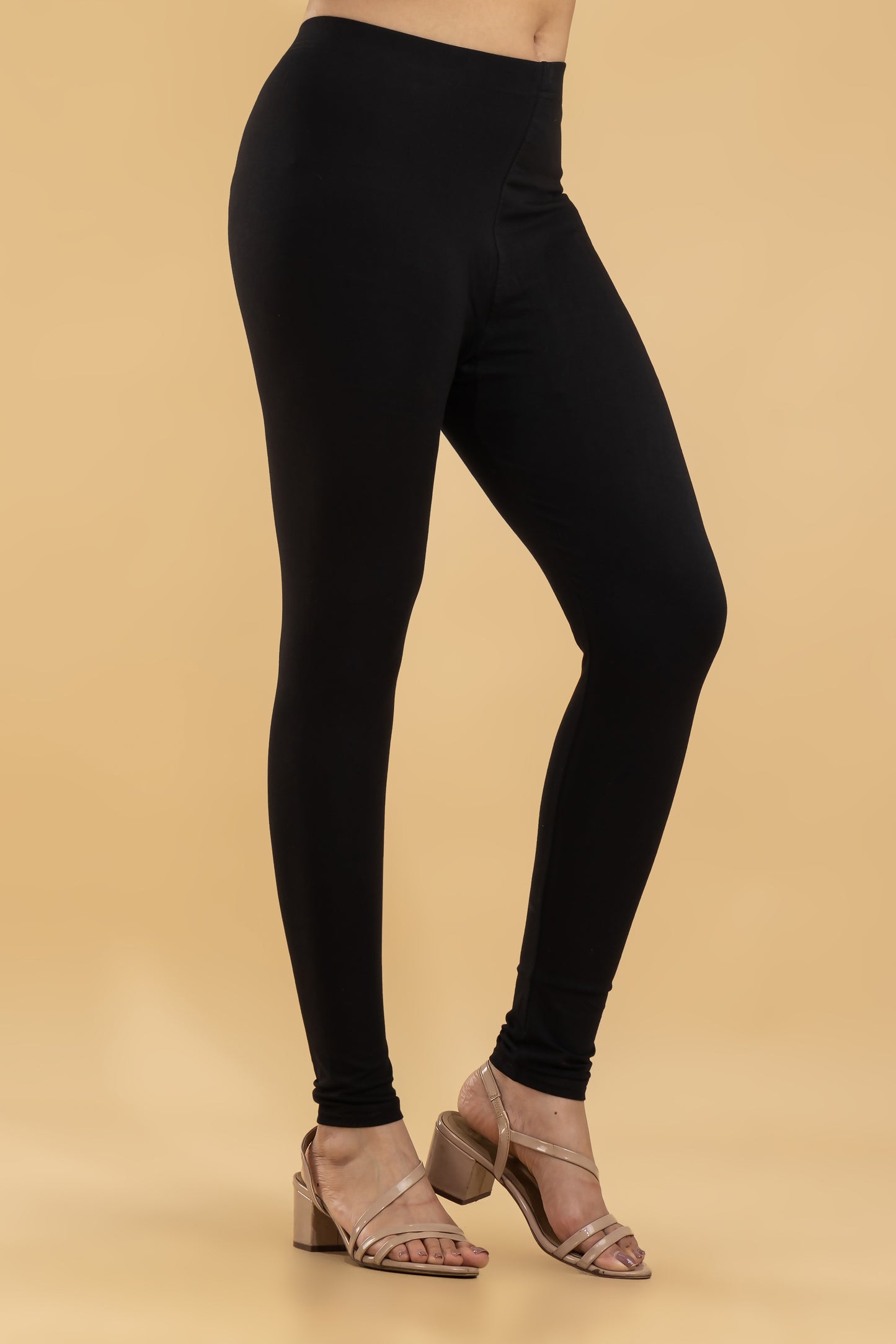 Black leggings worn by a person on a beige background