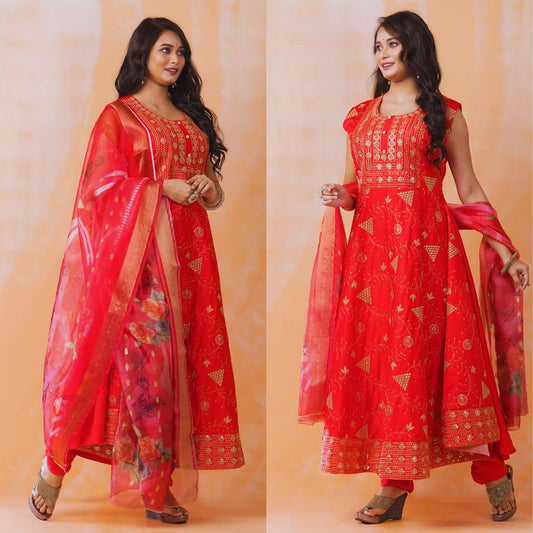 Woman wearing a red traditional outfit with gold patterns on an orange background