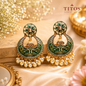 Ornate green and gold earrings with pearl drops on a decorative surface, featuring the TITOS Fashion House logo.