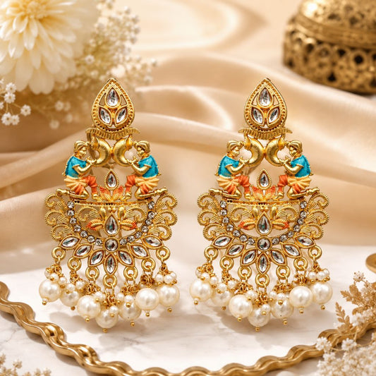 Ornate gold earrings with pearls and gemstones on a decorative background