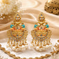 Ornate gold earrings with pearls and gemstones on a decorative background