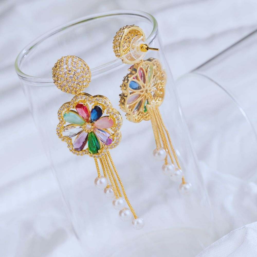 Colorful earrings with gold frames and tassels on a white background