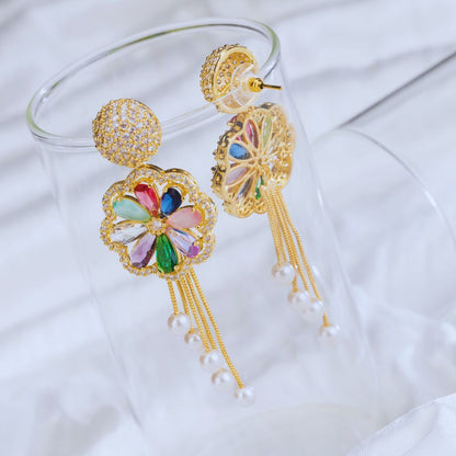 Colorful earrings with gold frames and tassels on a white background