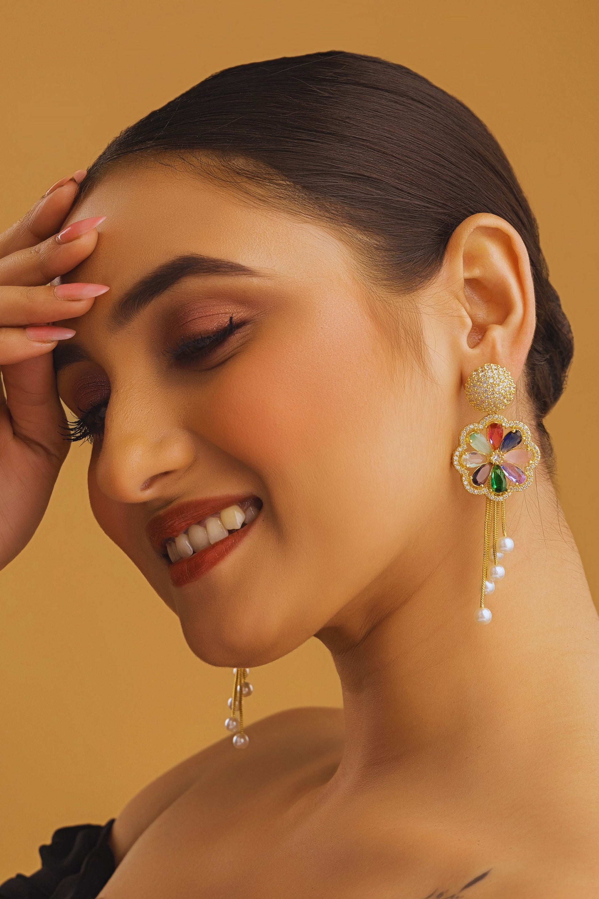 Woman wearing colorful earrings against a beige background