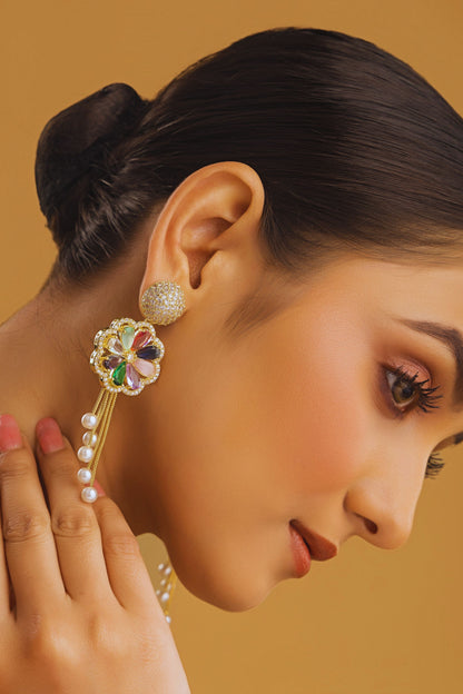 Close-up of a woman wearing an ornate earring with a brown background