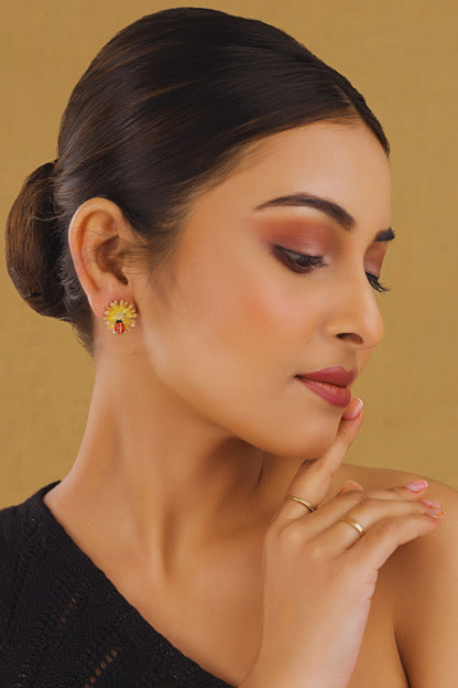 Woman wearing sunflower earrings with a beige background
