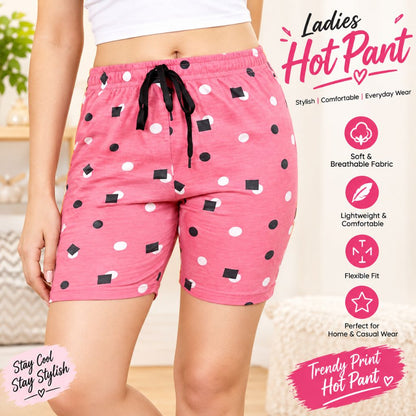 A person wearing pink hot pants with a black and white geometric print, shown from the waist to mid-thigh in a styled indoor setting. The image includes promotional text and feature callouts for the shorts.