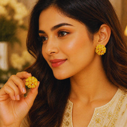 Woman wearing yellow floral earrings with a blurred outdoor background