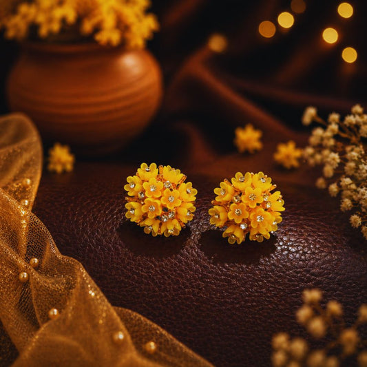 Yellow floral earrings on a dark surface with decorative elements