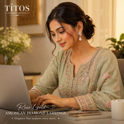 Woman in traditional attire using a laptop with 'TITOS Fashion House' branding.