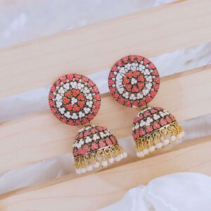 Traditional jhumkas in pink and white with gold accents, exemplifying exquisite Indian jewelry artistry and design